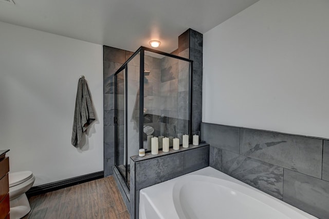 bathroom featuring wood finished floors, a garden tub, toilet, and a shower stall