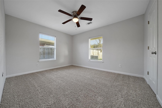 carpeted empty room featuring baseboards, visible vents, and ceiling fan