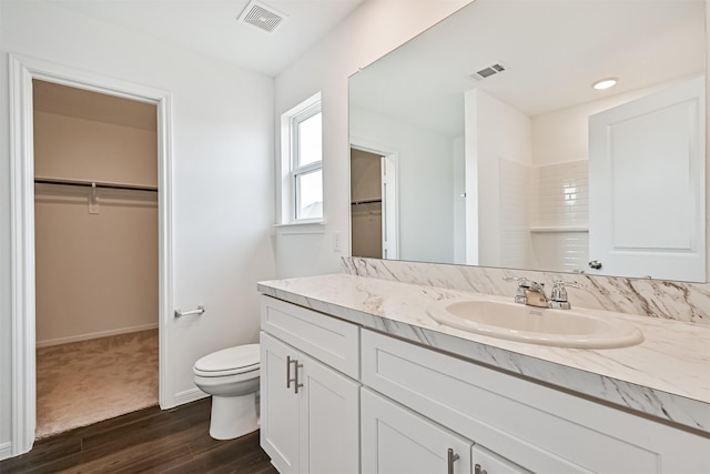 full bathroom featuring visible vents, vanity, wood finished floors, and toilet