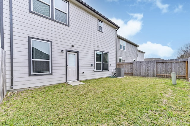 rear view of house featuring a fenced backyard, a yard, and central AC unit