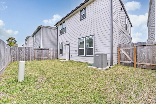 rear view of property featuring central AC unit, a lawn, and a fenced backyard