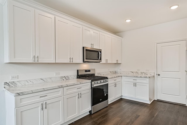 kitchen with light stone counters, dark wood-style flooring, stainless steel appliances, white cabinetry, and recessed lighting