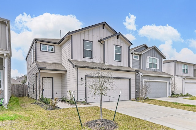 view of property with board and batten siding, a front lawn, driveway, and an attached garage