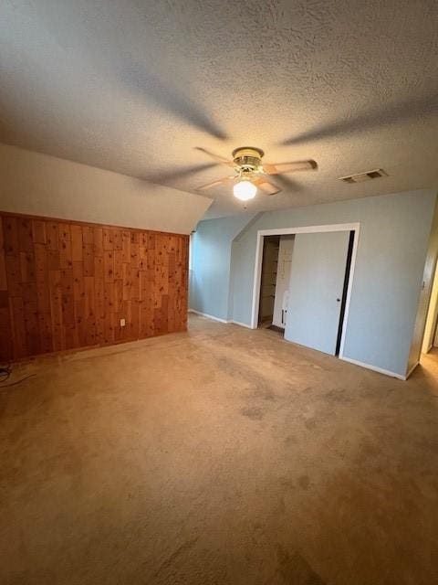 9427 Walnut Glen Dr, Houston, TX 77064 - bonus room featuring visible vents, ceiling fan, a textured ceiling, carpet floors, and wood walls