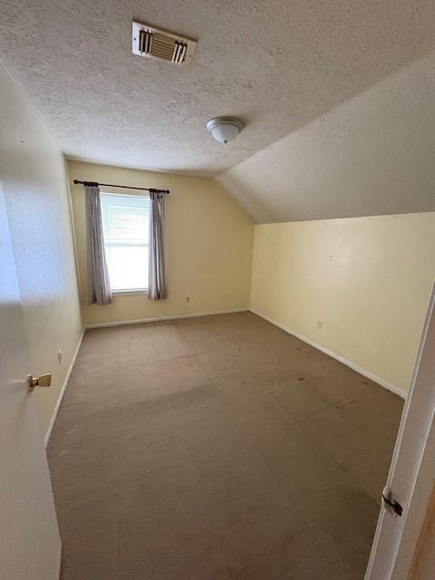 9427 Walnut Glen Dr, Houston, TX 77064 - bonus room featuring baseboards, vaulted ceiling, a textured ceiling, visible vents, and carpet