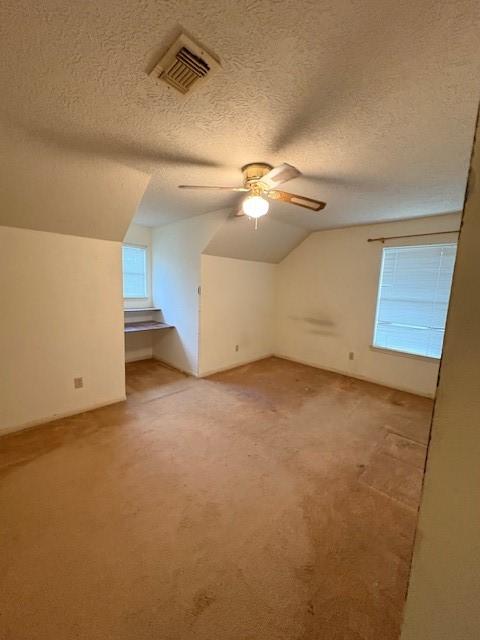 9427 Walnut Glen Dr, Houston, TX 77064 - additional living space with a ceiling fan, light carpet, vaulted ceiling, and visible vents
