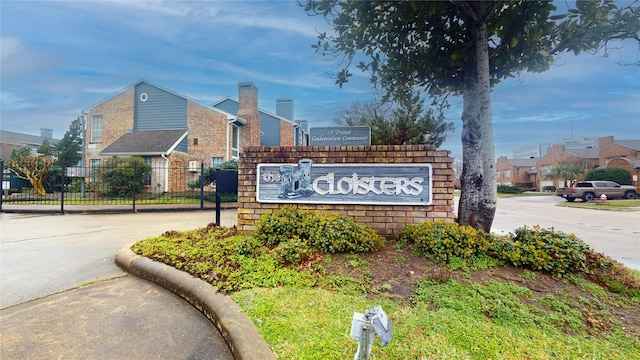 community / neighborhood sign featuring fence