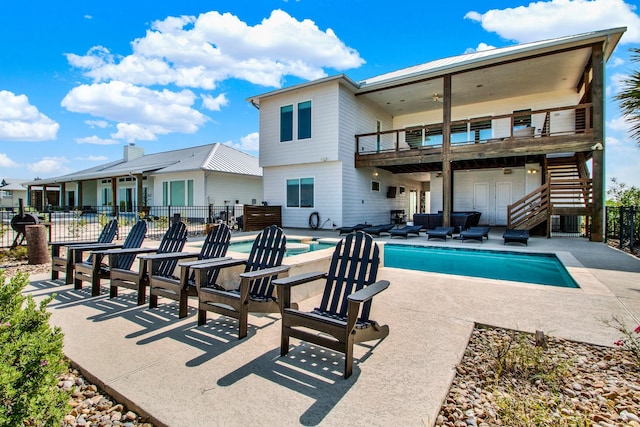 rear view of house featuring a patio, a balcony, fence, stairway, and a fenced in pool