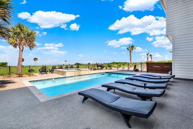 view of pool featuring a pool with connected hot tub, fence, and a patio