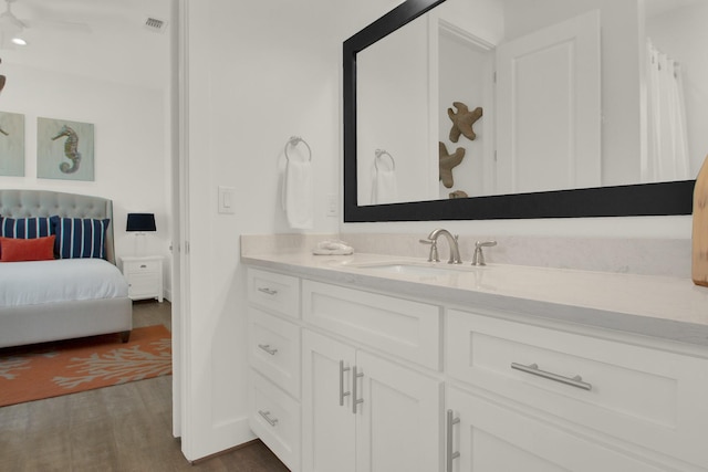 bathroom with visible vents, ensuite bath, wood finished floors, and vanity