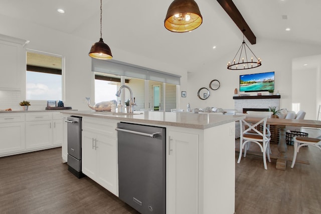 kitchen featuring vaulted ceiling with beams, an island with sink, dark wood finished floors, and open floor plan