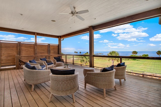 wooden terrace featuring a ceiling fan, outdoor lounge area, and a water view