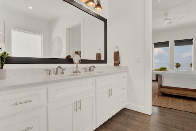 bathroom featuring double vanity, a sink, ensuite bathroom, and wood finished floors