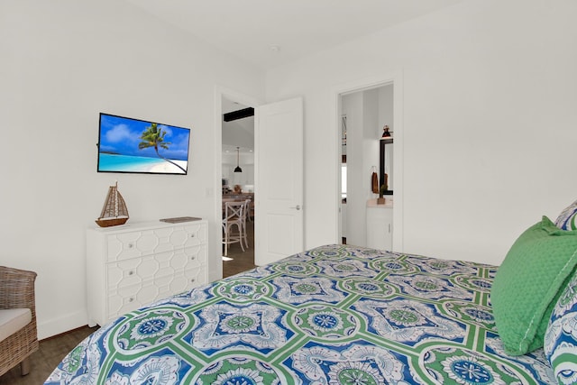 bedroom featuring dark wood-style flooring and connected bathroom