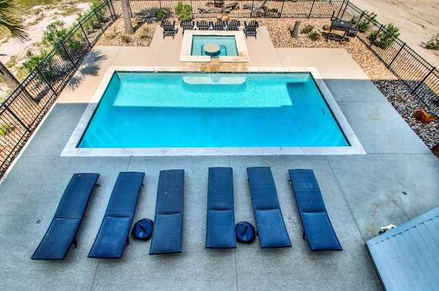 view of swimming pool featuring a fenced in pool, a patio area, fence, and an in ground hot tub