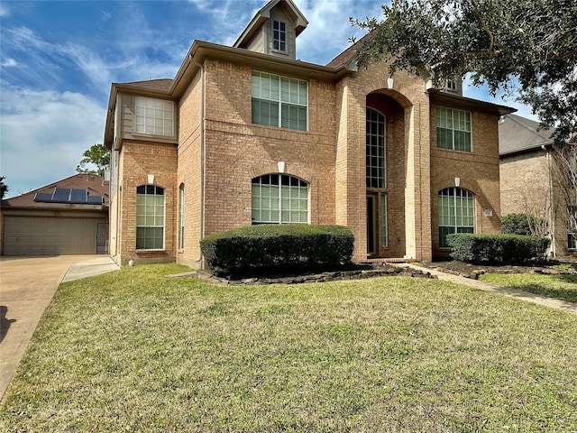 traditional-style house featuring a garage, brick siding, and a front lawn