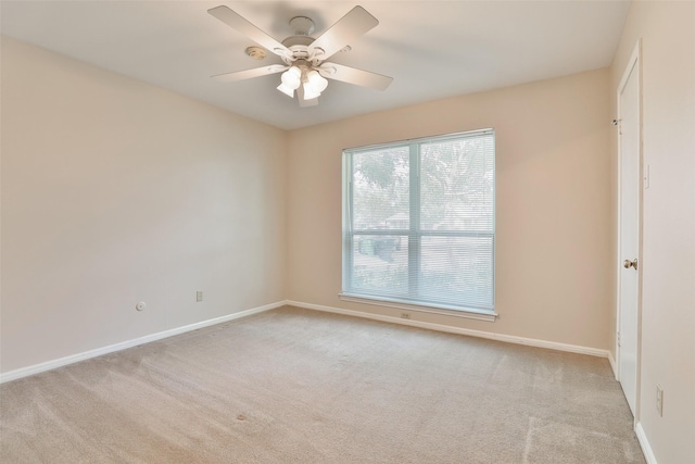 empty room featuring light colored carpet, ceiling fan, and baseboards