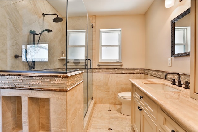 bathroom featuring a stall shower, tile walls, toilet, and vanity