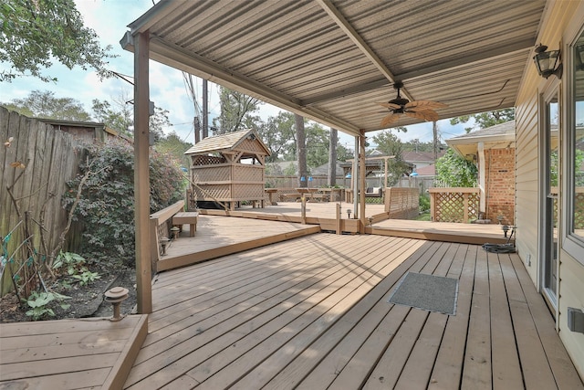 wooden terrace featuring a fenced backyard, ceiling fan, and a gazebo