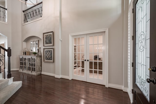 foyer entrance with stairs, baseboards, wood finished floors, and french doors