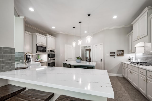 kitchen with a breakfast bar, stainless steel appliances, light countertops, ornamental molding, and a peninsula