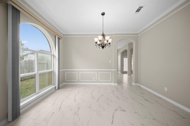 spare room featuring ornamental molding, arched walkways, marble finish floor, and a chandelier