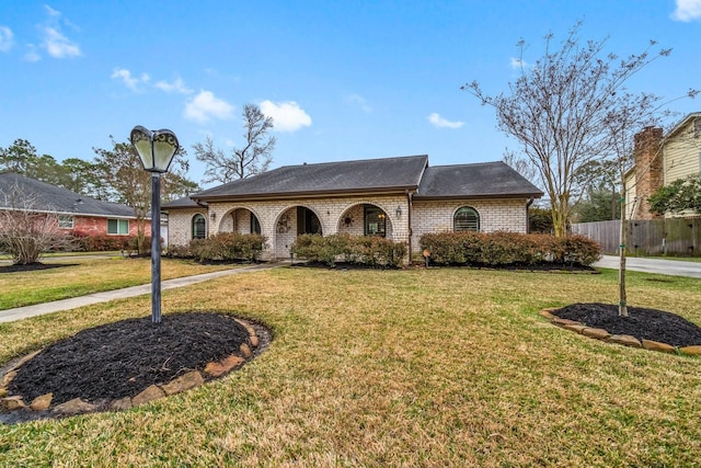 view of front of property with a front yard, fence, and brick siding