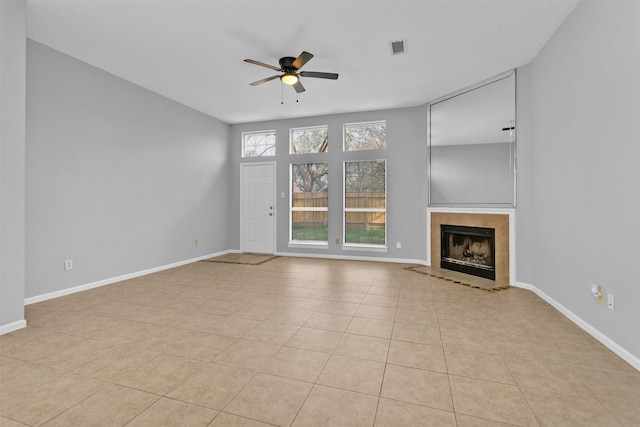 unfurnished living room featuring a ceiling fan, baseboards, visible vents, and a tiled fireplace