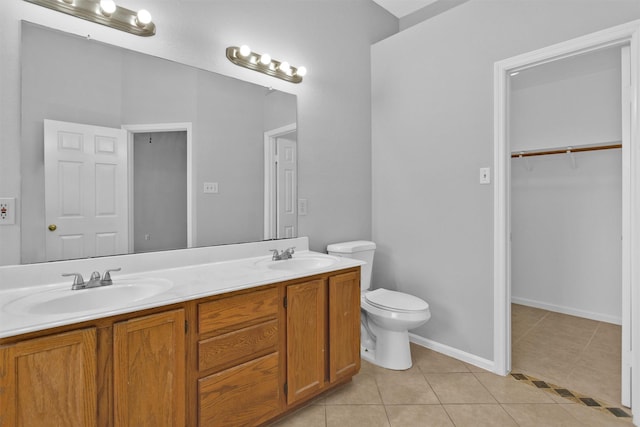 full bath featuring toilet, tile patterned flooring, double vanity, and a sink