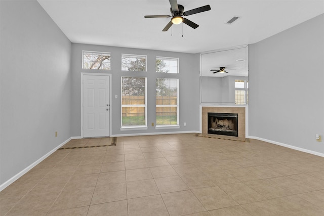 unfurnished living room featuring baseboards, visible vents, a tiled fireplace, and tile patterned floors