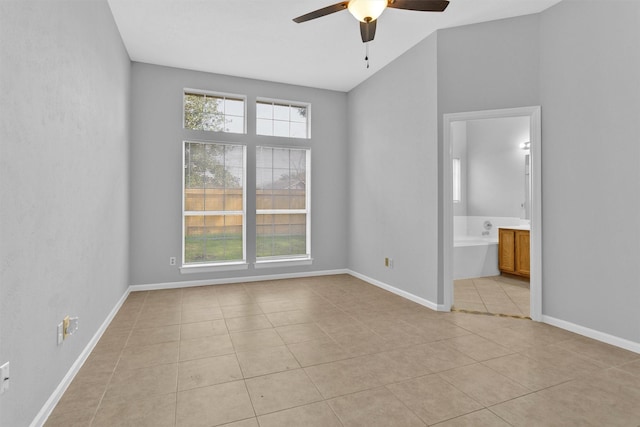 unfurnished room with light tile patterned floors, a ceiling fan, and baseboards