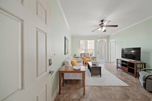 living area with ceiling fan, ornamental molding, and baseboards