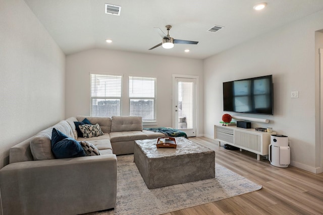 living room featuring light wood finished floors, visible vents, and a wealth of natural light