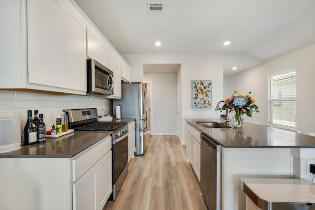 kitchen featuring dark countertops, visible vents, stainless steel appliances, and a sink