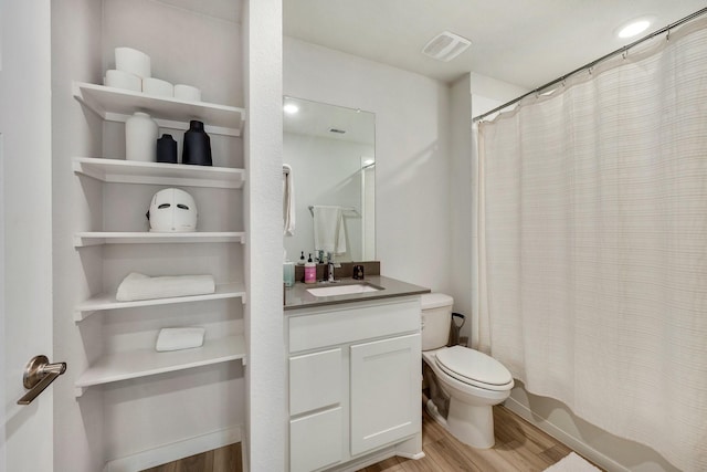 bathroom featuring visible vents, toilet, shower / bath combo, vanity, and wood finished floors