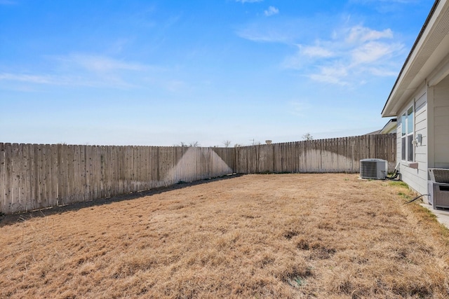 view of yard with central air condition unit and a fenced backyard