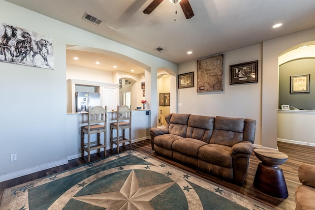 living area featuring arched walkways, wood finished floors, visible vents, and recessed lighting