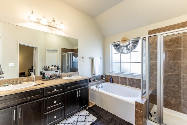 ensuite bathroom with double vanity, a sink, a bath, and a shower stall