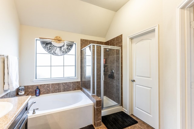 bathroom with a stall shower, lofted ceiling, vanity, and a bath