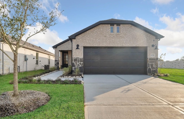 view of front of property featuring cooling unit, a garage, brick siding, concrete driveway, and a front lawn