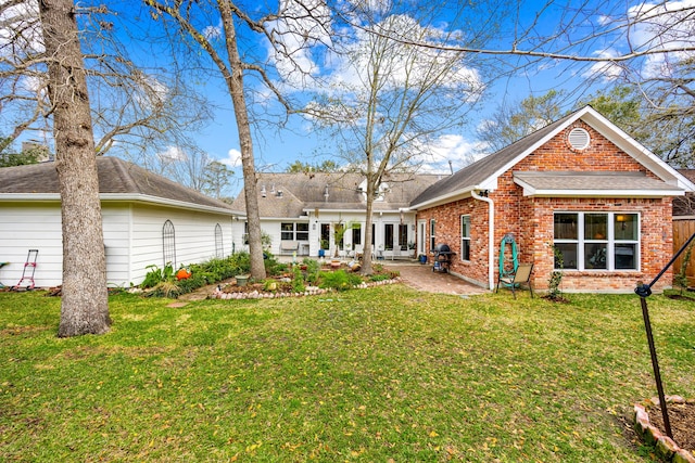 back of property with brick siding, a shingled roof, french doors, a lawn, and a patio area