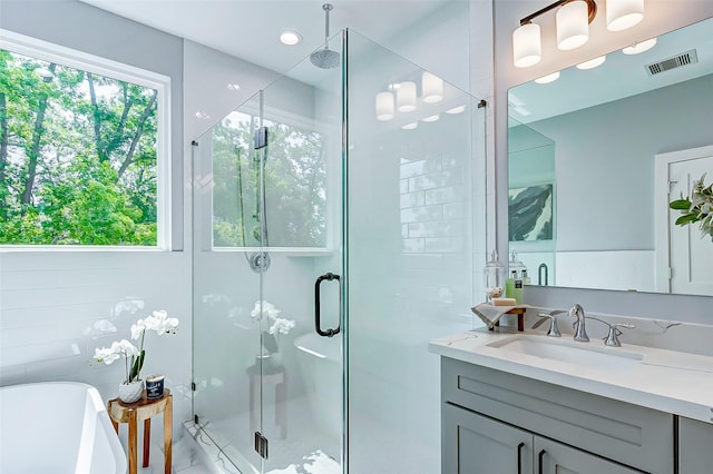 bathroom featuring a freestanding tub, visible vents, a shower stall, and vanity