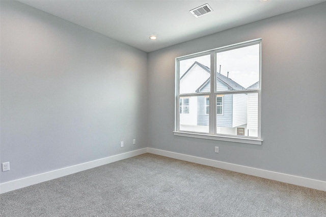 empty room featuring recessed lighting, visible vents, light carpet, and baseboards