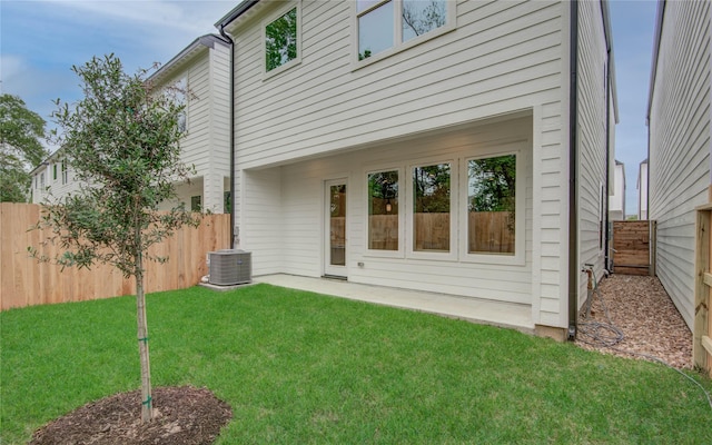 back of house featuring a yard, fence, and central air condition unit