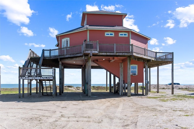 exterior space featuring a carport, stairway, and a deck with water view