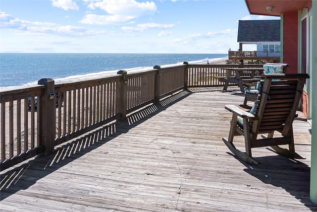 deck with a beach view and a water view