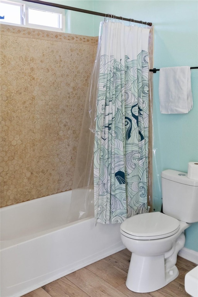 bathroom featuring shower / bath combination with curtain, wood finished floors, and toilet