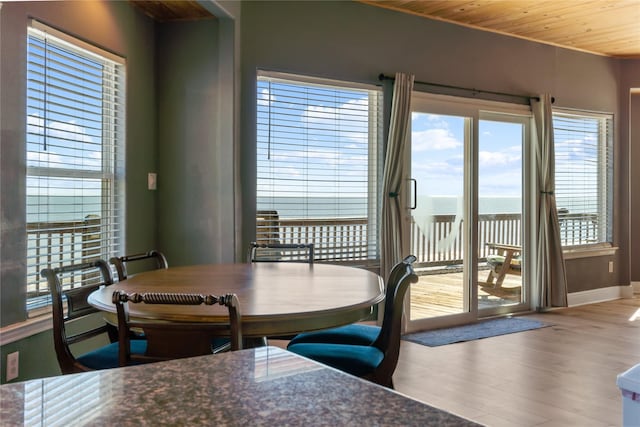 dining space with wooden ceiling, wood finished floors, and baseboards