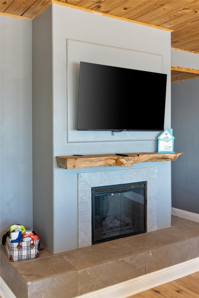 interior details featuring wood ceiling, a fireplace, baseboards, and wood finished floors