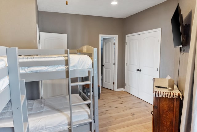 bedroom with light wood-type flooring, a closet, and recessed lighting